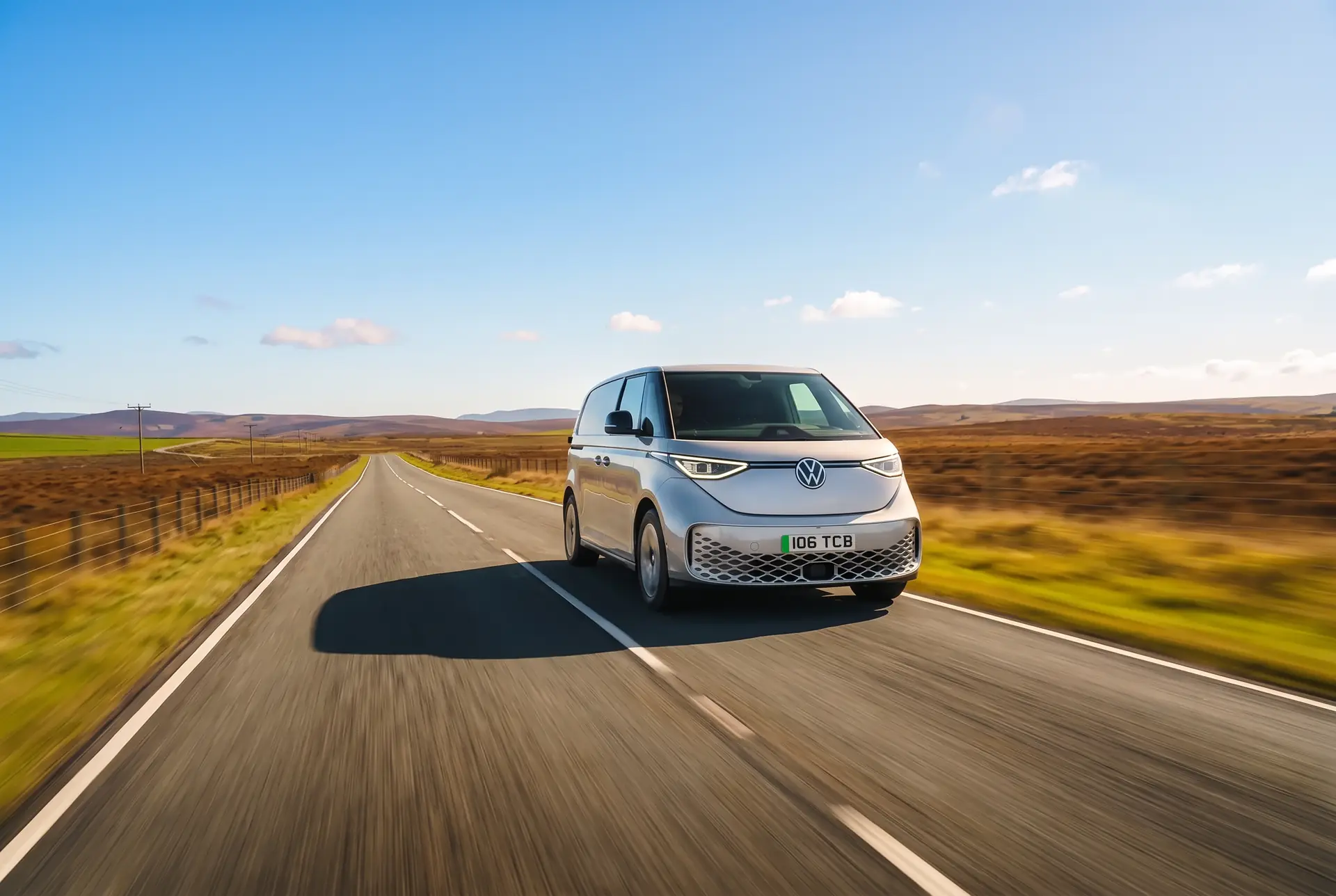 Silver Volkswagen ID. Buzz Cargo driving on an open moorland road on a sunny day