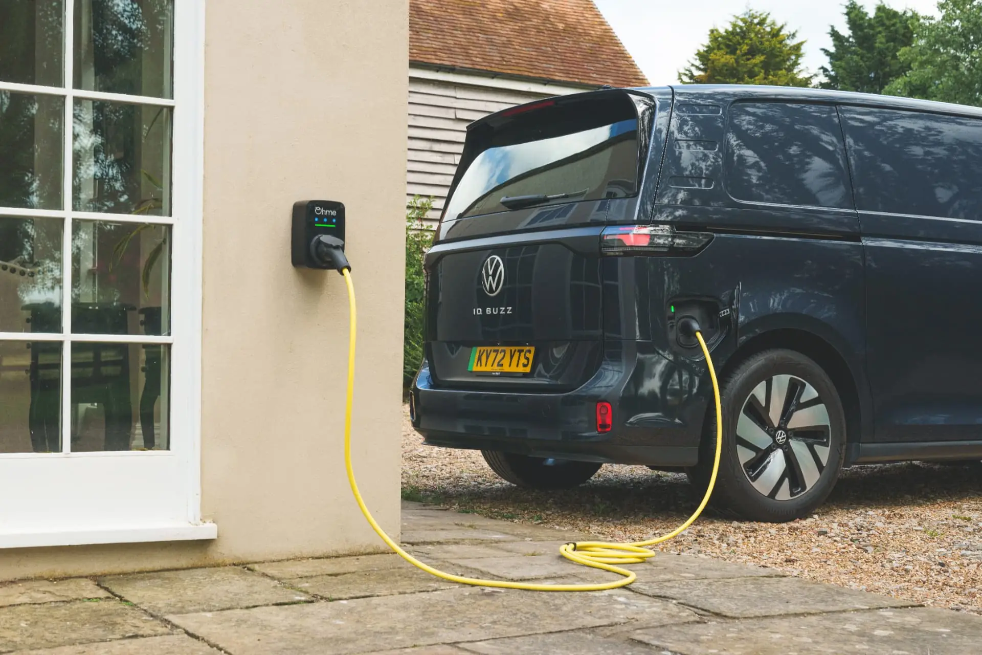 Dark blue Volkswagen ID. Buzz Cargo charging from a home wallbox