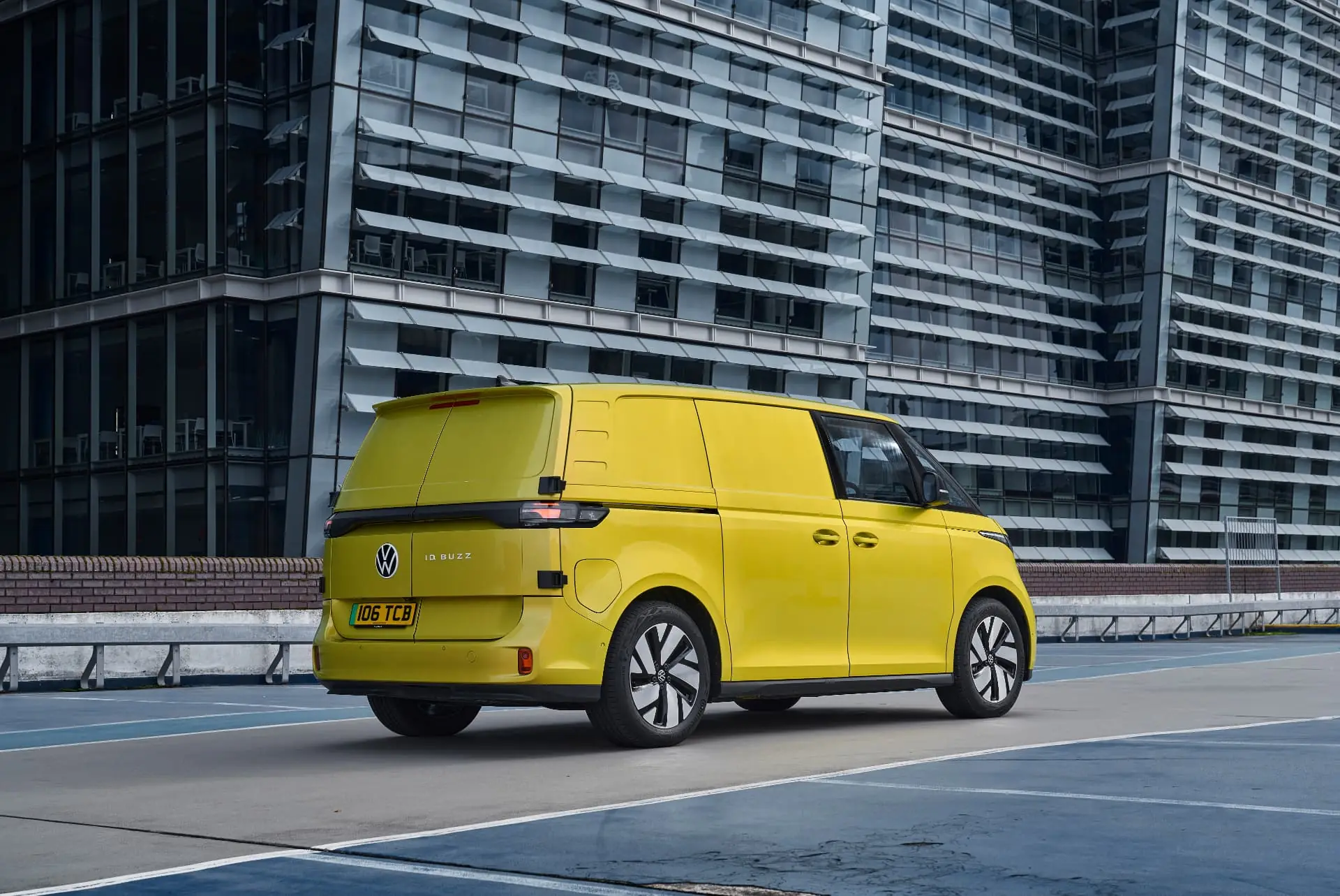 Rear three-quarter view of a yellow Volkswagen ID. Buzz Cargo in a city car park