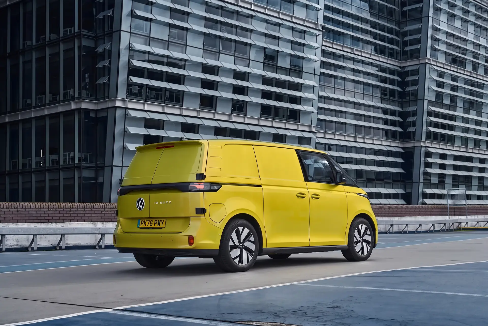 Rear three-quarter view of a yellow Volkswagen ID. Buzz Cargo in a city car park
